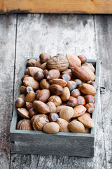 Various  nuts in wooden box on rustic table