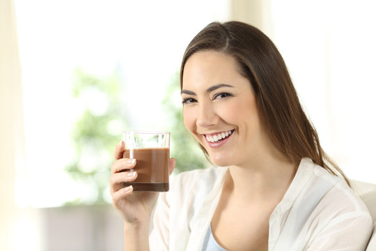 Girl holding a cocoa shake looking at you