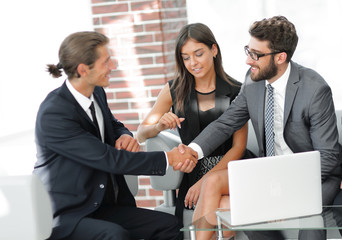 handshake business partners,sitting on the sofa