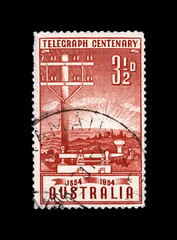 telegraph pole and key, 100th anniversary of inauguration of the telegraph in Australia, circa 1954. canceled vintage post stamp printed in Australia isolated on black background.