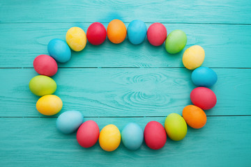 Frame of Easter eggs on blue wooden background. Top view and copy space. Mock up. April holiday. Food egg.