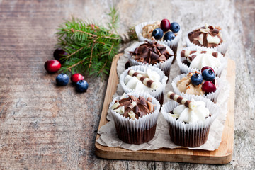 Chocolate  mini cupcakes with christmas decoration on wooden table