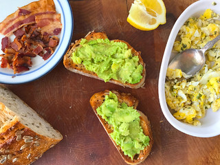Preparing avocado toast with scrambled eggs and bacon © nebari