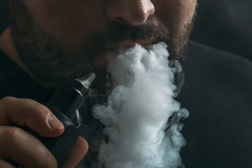 Vaping man close up. Smoker exhale vapor cloud, vape concept