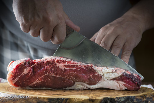 Carnicero cortando carne de ternera para la comida