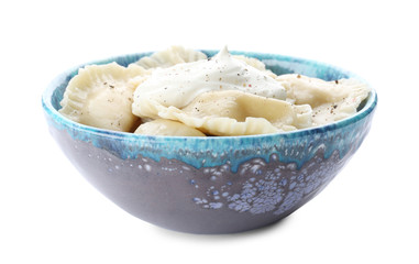Tasty dumplings with sour cream in bowl on white background