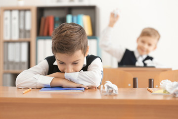 Bullied little boy in classroom