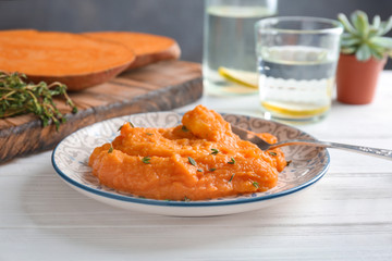 Plate with tasty mashed sweet potato on table