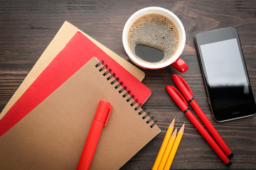 Office stationery, cup of coffee and phone on table