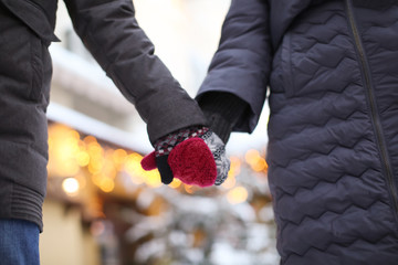 Obraz premium Young loving couple holding hands outdoors on winter day