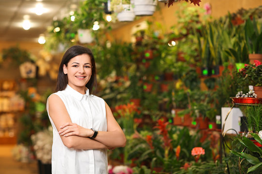 Portrait of young woman in greenhouse. Small business owner