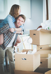 Couple unpacking cardboard boxes in their new home. Young couple.