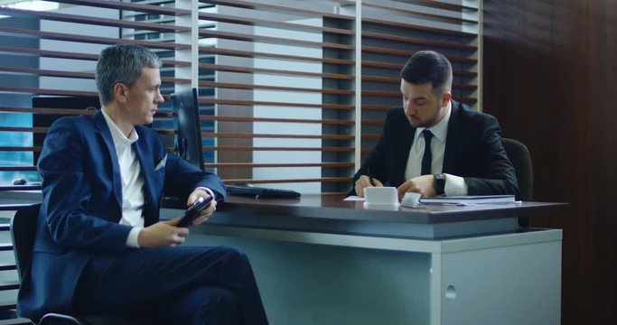 Customer sign contract in showroom, then sales manager check credit card of client and looking on computer screen