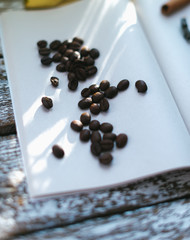 Coffee beans on a notepad on a wooden background.