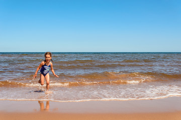 Fototapeta na wymiar Little girl playing on the Cavendish beach