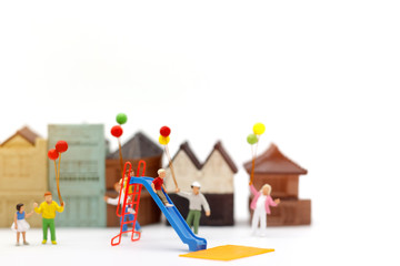 Miniature people, family and children enjoy with colorful balloons, happy family day concept.