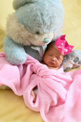 asian newborn baby sleeping with teddy bear. growth and childhood concept