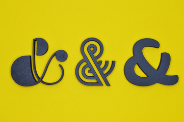 three black ampersand characters on yellow background