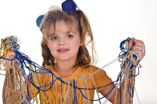 Little Girl Holding Tangled Yarn Of Wool For Knitting In Her Hands