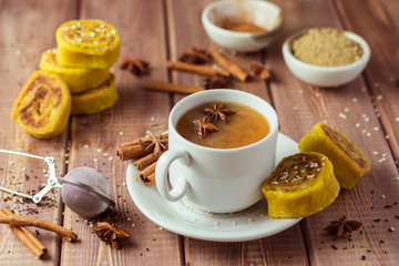 Indian tea masala with spices in white cup, Indian food on wooden table
