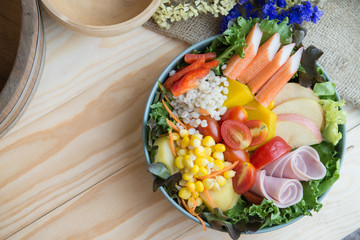 Obraz na płótnie Canvas Top view of fresh vegetable salad on wood background.