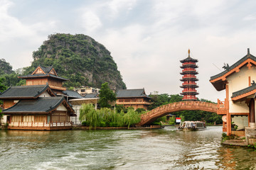 Wooden houses and beautiful bridge over lake in Guilin