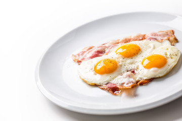 Ham and Eggs. Bacon and Eggs. Salted egg with pepper on white plate. English breakfast