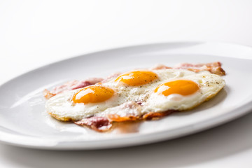 Ham and Eggs. Bacon and Eggs. Salted egg with pepper on white plate. English breakfast