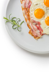 Ham and Eggs. Bacon and Eggs. Salted egg with pepper on white plate. English breakfast