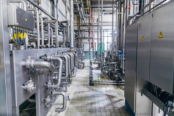 Modern factory interior. Stainless steel pipeline with valve and, manometers, switch boxes