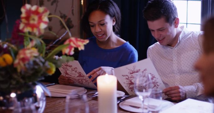 4k, A happy young couple looking at their menu's at a fancy restaurant. Slow motion