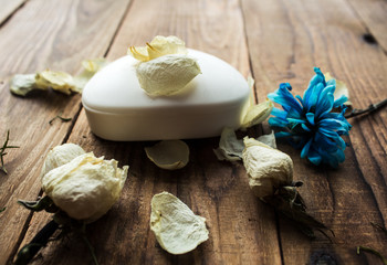 soap and white rose and violet on a wooden background