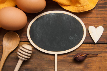 Cholkboard Topper for Text Mesage or Food Blog. . Cooking Process, Food and Recipe Concept. Orange Napkin, Eggs, Heart Shape over Textured Rustic Wooden Table.