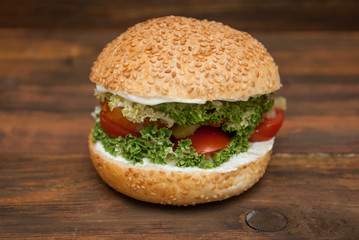 Step by Step Cooking process of Homemade Hamburger with Fresh Letuce leaves, tomatoe Slice, Meat. Homemade Healthy Food or Fast food, with fresh Vegetables on rustic Wooden Background.