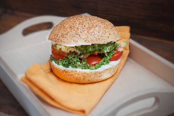 Top view of Homemade Hamburger in Wooden heart Shape box, with fresh Vegetables on rustic Wooden Background with copy Space. Orange Napkin.