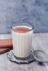 A glass of Milk with cinnamon or cocoa Powder with biscuits on rustic background. Healthy Breakfast.