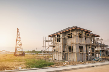 Residential new house building at construction site with clouds and blue sky