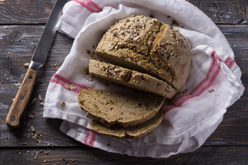 Simple rustic rye oat bread without yeast with seeds on a wooden table, selective focus