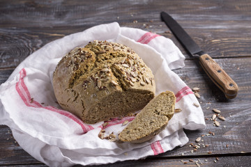 Simple rustic rye oat bread without yeast with seeds on a wooden table, selective focus