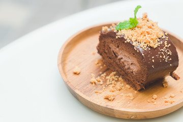 Fototapeta na wymiar good taste dessert with chocolate roll cake on wood dish of copy space