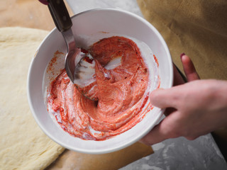 Cooking pizza. Dough with tomato sauce. woman hands