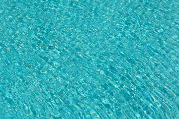 Water ripples on blue tiled swimming pool background. Top view