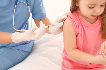 Doctor vaccinating little child in clinic