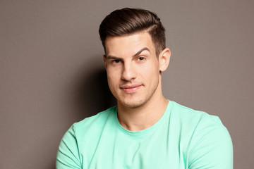Fototapeta premium Young man with raised eyebrow on grey background