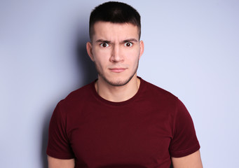 Obraz premium Emotional young man with dyed eyebrows on light background