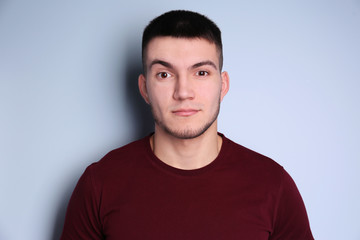 Young man with dyed eyebrows on light background