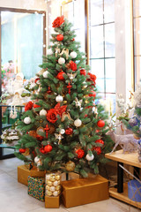 Beautiful Christmas tree decorated by professional florist in flower shop