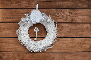 Beautiful Christmas wreath made by professional florist hanging on wooden background