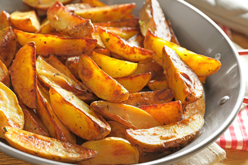 Dish with tasty potato wedges, closeup