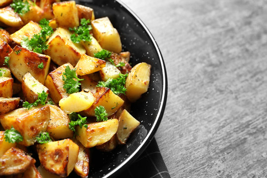 Dish with tasty potato wedges on table